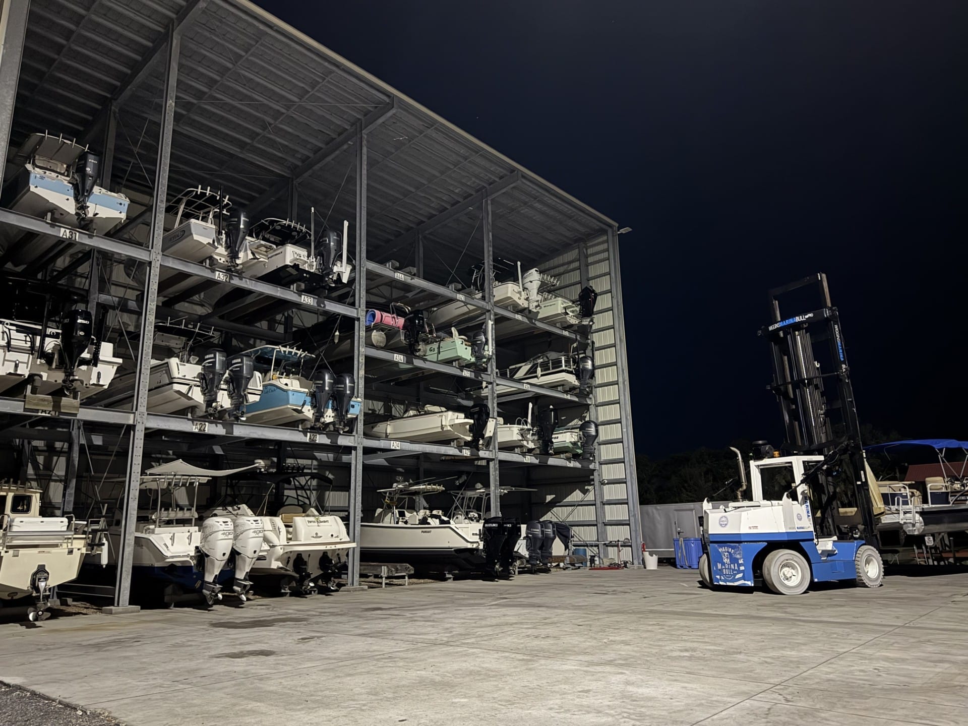 Image of our dry stack with boats and the forklift.