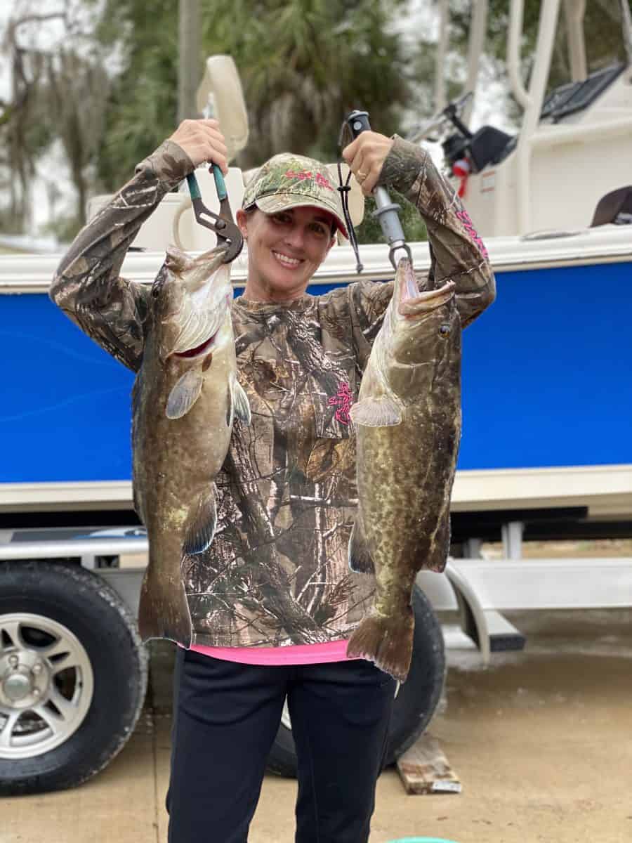 Woman holding two large fish